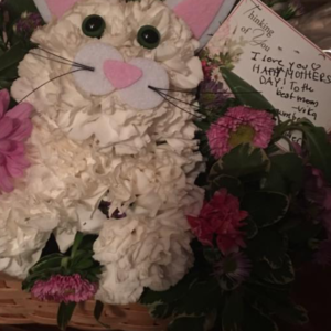 Flower arrangement shaped to look like a cat. 